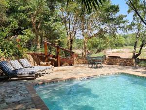 侯斯普瑞特Paradise River Lodge的一个带庭院和桌椅的游泳池