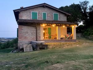 萨韦纳河畔圣拉扎罗Casale IL SAMBUCO sui colli bolognesi的一座小石头房子,位于山上,设有烧烤设施