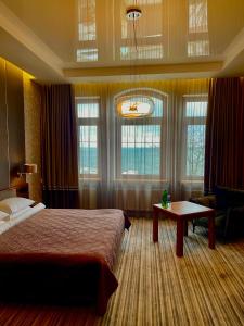 敖德萨Villa-Sofia Mini-hotel的卧室配有床、桌子和窗户。