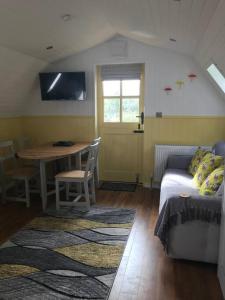 普里茅斯Bumble Bee Cottage的客厅配有桌子和沙发