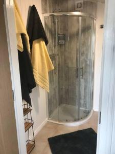 普里茅斯Bumble Bee Cottage的浴室里设有玻璃门淋浴