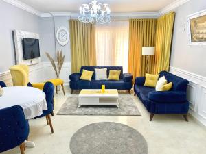 十月六日城Cozy Apartment (JANNA)的蓝色的客厅配有蓝色的沙发和黄色的枕头