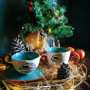 凯麦尔Çiftlik ve Dağ evi Kemer - Canerbey的桌子上两个咖啡杯,上面有圣诞树