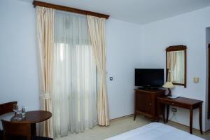 柳布什基哈姆酒店的一间卧室配有一张床、镜子和电视