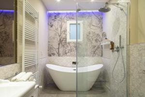 佛罗伦萨Ricasoli Garden Relais的带浴缸和玻璃淋浴间的浴室。