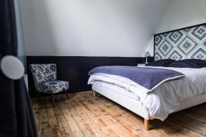 弗尔黎祖La Villa de l'Etoile 10 personnes的一间卧室配有一张床和一把椅子