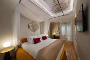 佛罗伦萨Ricasoli Garden Relais的卧室配有带红色枕头的大型白色床