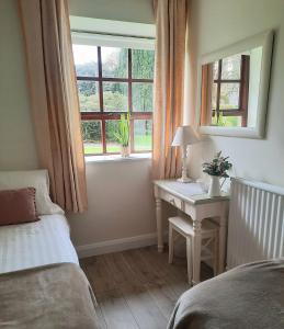 五英里镇Blessingbourne Cottages & Apartments的一间卧室配有一张床、一张书桌和一个窗户。