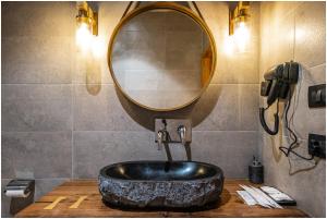 列城essence AT LADAKH的浴室设有黑色水槽和镜子