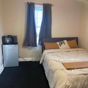 Saint AlbansDon cozy的一间卧室配有一张床、一台电视和一个窗口