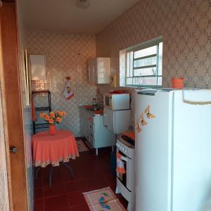 阿瓜斯-迪圣佩德罗Recanto Panapaná - suítes的小厨房配有白色冰箱和桌子