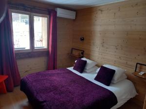 丰罗穆Eco-Logis des Cabris的一间卧室配有一张大床和紫色毯子
