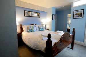 科尔温湾布林恩乌兰德斯酒店的一间卧室配有一张带蓝色墙壁的大床