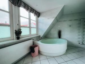 罗斯托克Lieblingsapartment No.12 für bis zu 6 Gäste的白色的浴室设有浴缸和窗户。