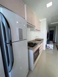 伊塔佩马Apartamento Novo e Confortável的白色的厨房配有冰箱和炉灶。