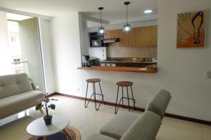 麦德林Apartamento Completo Poblado - Ubicacion Central con Parqueadero的带沙发和椅子的客厅以及厨房。