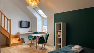 扎莫希奇Hotel77的一间卧室设有绿色墙壁和桌椅