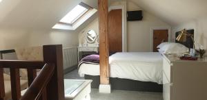 锡豪西斯Ugiebrae House Bed & Breakfast的阁楼卧室配有床和镜子