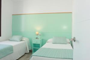 卡拉恩·布拉內斯Yucas Homes的蓝色和白色的客房内的两张床