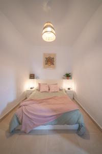 阿里亚Casa Carmen的一间白色客房内配有一张大床的卧室