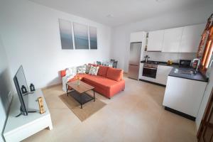 阿里亚Casa Carmen的一间带橙色沙发的客厅和一间厨房