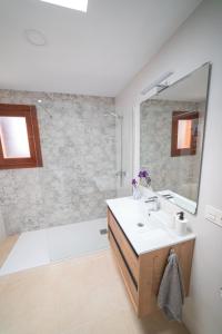 阿里亚Casa Carmen的一间带水槽、浴缸和镜子的浴室