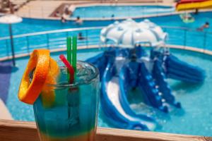 伊罗达Elounda Water Park Residence Hotel的水上公园前的桌子上喝一杯