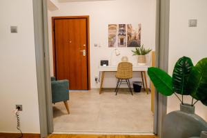 雅典Newly Renovated Apartment 7 min walk from Acropolis的一间房间,配有书桌和植物桌子