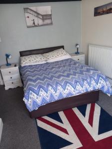 斯凯格内斯Saracens Head The Annex的一间卧室配有一张红色白色和蓝色棉被的床