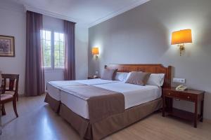 科尔多瓦Crisol Jardines de Córdoba的一间卧室配有一张大床和一张桌子及电话