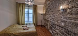 塔林Old Town Tallinn Luxury Residence的一间卧室设有砖墙和一张床