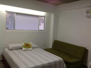 哥伦比亚港Hostal Donde Marle的卧室配有床、椅子和窗户。