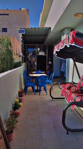 瓦迪穆萨Its your choice hostel的庭院配有蓝色的椅子和桌子,庭院配有遮阳伞。