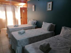 科皮亚波Tikay Suite Hotel的客房设有两张床和窗户。