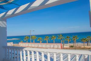 莫哈卡尔La Esperanza Beach- Zona Pubs y Restaurantes的享有海滩和棕榈树景致的阳台