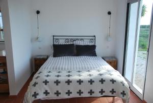 费雷拉杜阿连特茹Monte Ramos的一间卧室配有一张带黑白色棉被的床