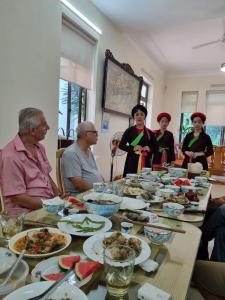 北宁Quanho Villa的一群人坐在桌子旁吃着食物