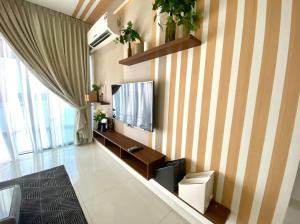 新山Royal Strand Danga Bay Abang Payung的一间客厅,墙上有条纹的电视