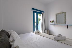帕罗奇亚Porto Bello di Paros的一间卧室配有一张带镜子的床和窗户