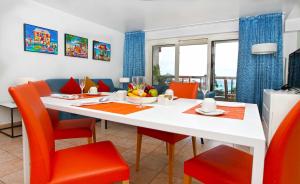 LowlandsRoyal Islander Club Resort La Terrasse的一间配备有白色桌子和橙色椅子的用餐室