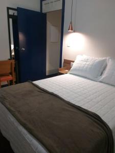 欧鲁普雷图A3EM Casa de Gorceix的卧室配有一张白色大床和一扇蓝色门