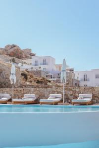米克诺斯城Arocaria Mykonos的一个带躺椅和遮阳伞的游泳池