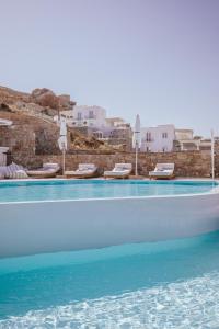 米克诺斯城Arocaria Mykonos的一个带椅子和遮阳伞的游泳池