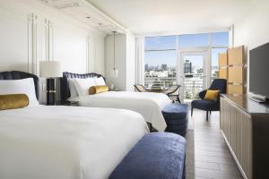 迈阿密海滩The Ritz-Carlton, South Beach的一间酒店客房,设有两张床和电视