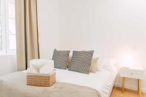 波尔图Oporto Yellow Villas的白色卧室配有带枕头的床和窗户