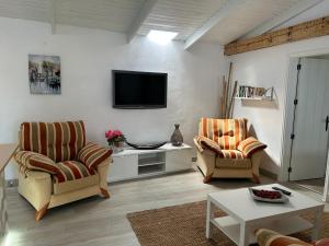 加拉奇科Casa La Oliva的客厅配有两把椅子和电视