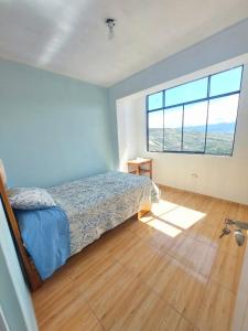 阿亚库乔Disha's Home Casa Hospedaje的一间卧室设有一张床和一个大窗户