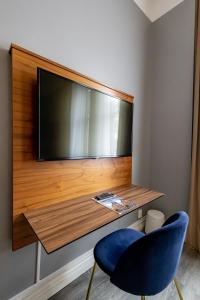 厄勒布鲁亚尔马酒店的墙上的平面电视和蓝色椅子