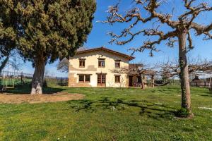 赫罗纳Can Salvà Casa rural en magnífico entorno natural的两棵树田里的房子