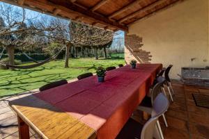 赫罗纳Can Salvà Casa rural en magnífico entorno natural的天井上配有一张长木桌子和椅子